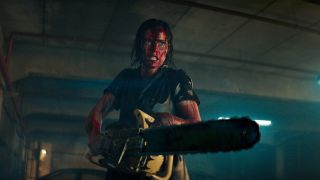 A blood soaked Lily Sullivan wielding a chainsaw in Evil Dead Rise.