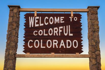 Welcome to Colorful Colorado road sign situated along Interstate I-76 against a sunset backdrop