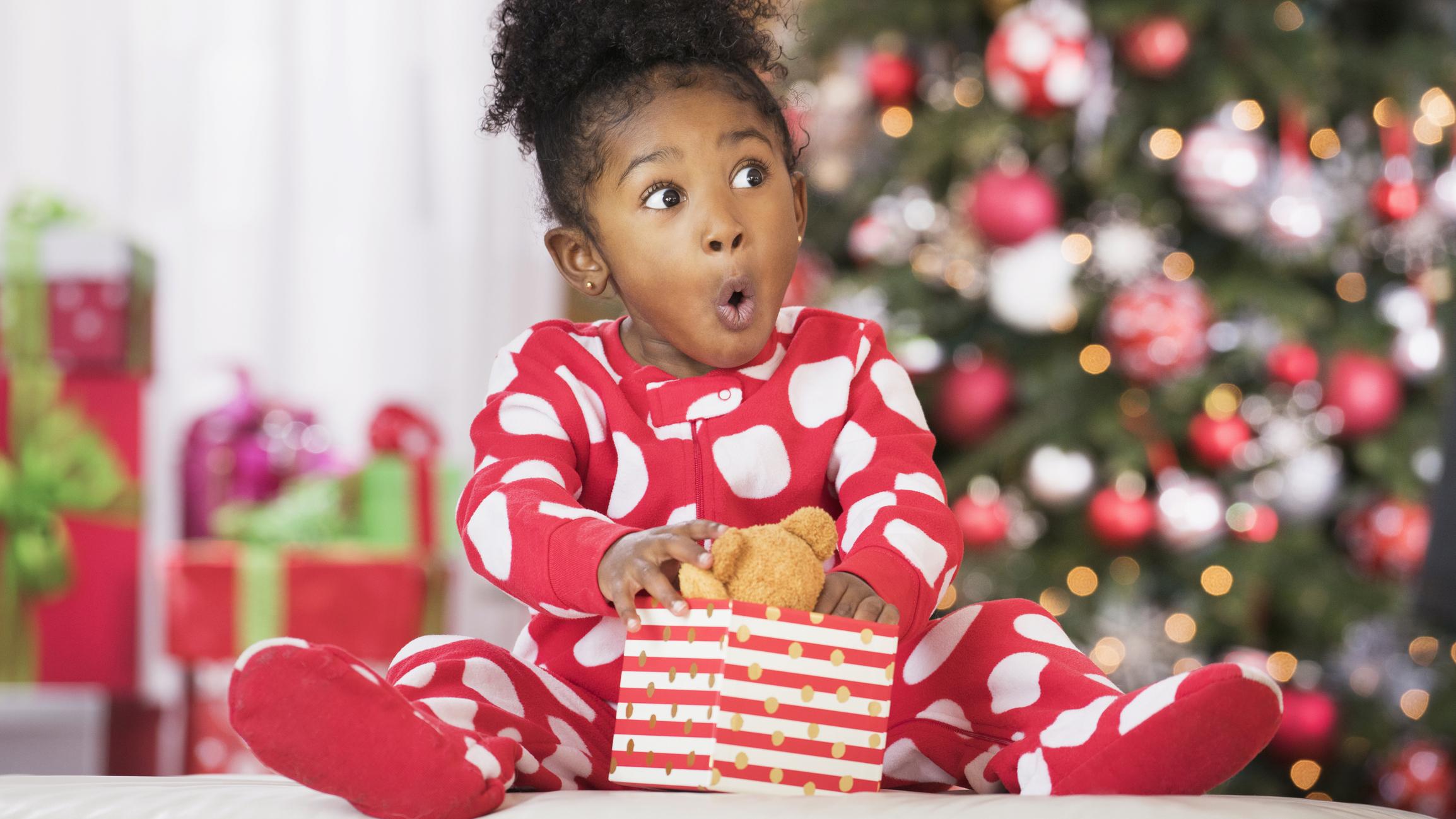  Surprised girl holding teddy bear toy on Christmas 