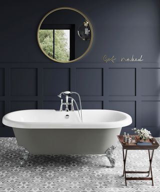 Dove grey freestanding bath with navy wall paneling by Bathroom Mountain
