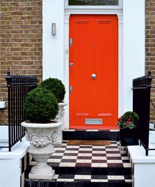 red front door with black and white paving