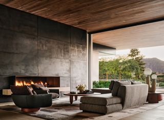 a large architectural living room with a fireplace and opening to a californian yard