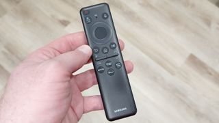Samsung OLED S90C remote held in palm of hand