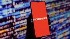 Fortinet logo is displayed on a smartphone screen in front of code background