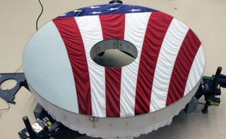 The primary mirror of The Roman Space Telescope reflects the U.S. flag.