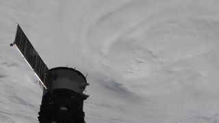 A white disk of clouds sits on a dark background