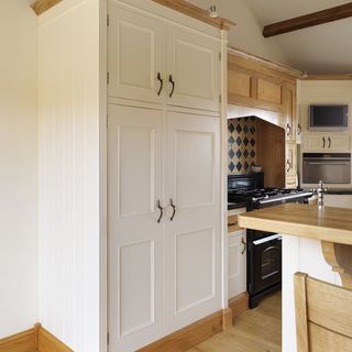 kitchen area with white tall and cupboard and wooden floor