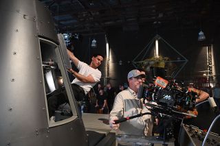 Colin O'Donoghue, portraying astronaut Gordon Cooper, films with a Mercury spacecraft mockup for National Geographic's "The Right Stuff." The series' recreated MASTIF, or gimbal rig, can be seen in the background on the Orlando, Florida sound stage.