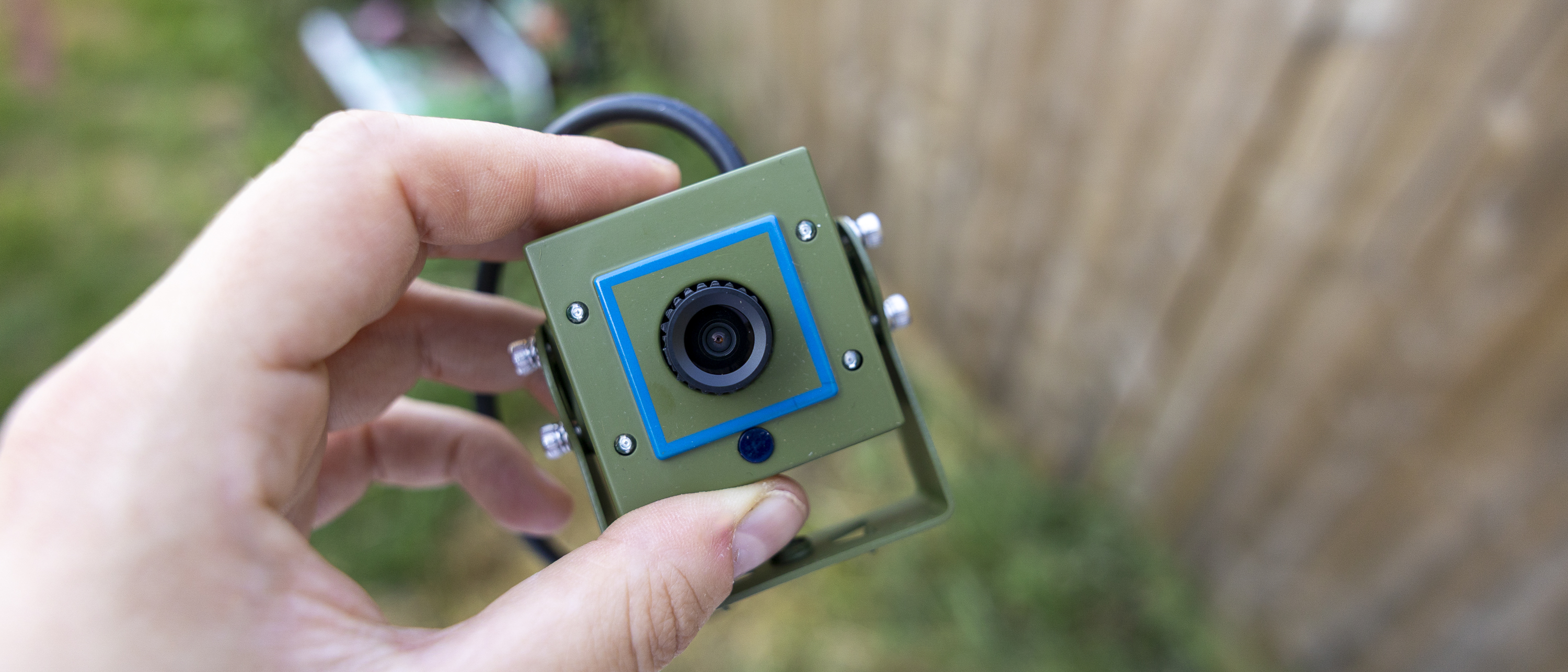 A female hand holding the Green Feathers bird box camera
