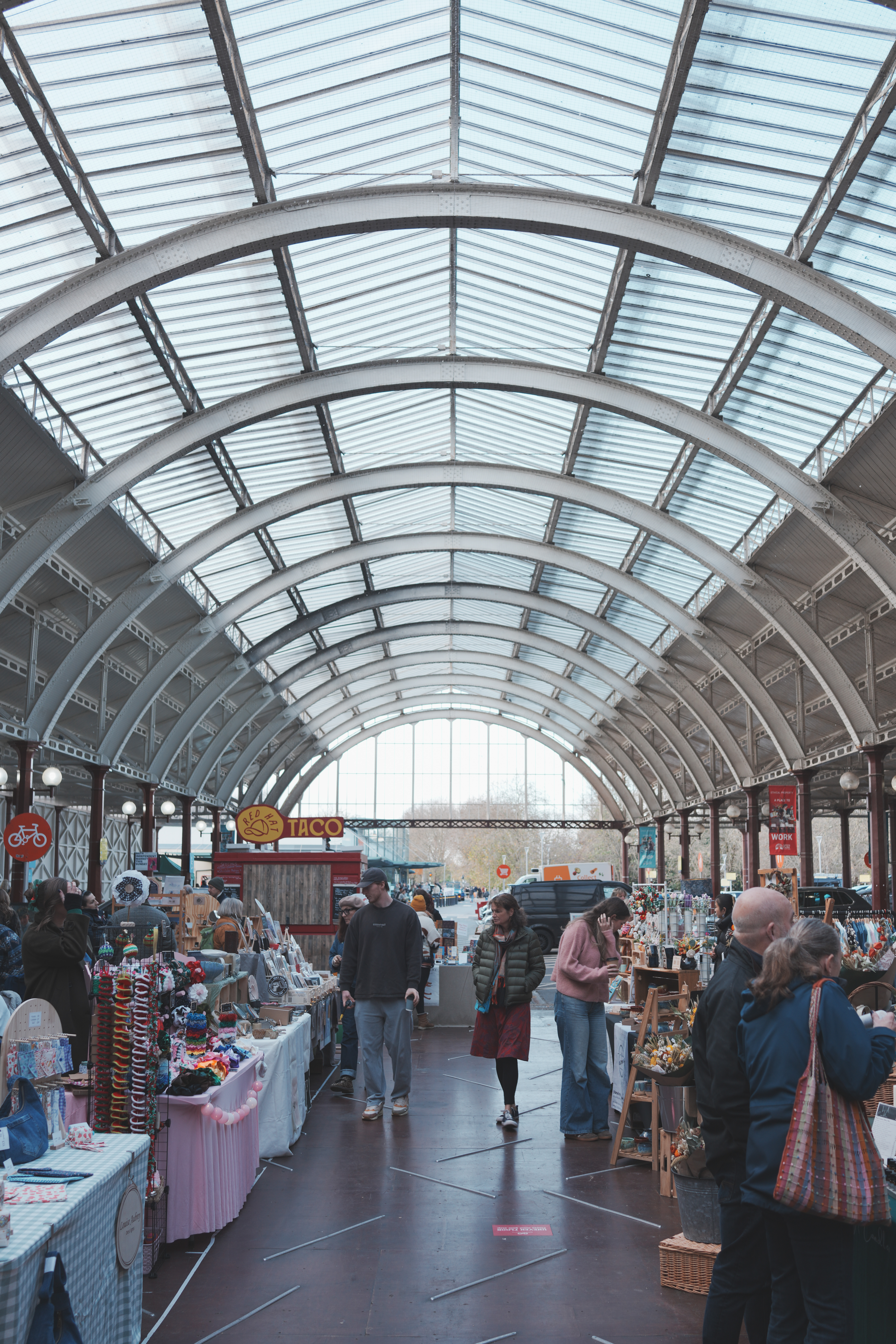 A photo of a market under a vaulted train station roof