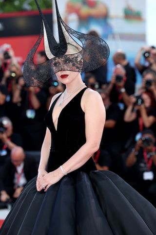 Lady Gaga wears a black lace headpiece by Philip Treacy at the Joker premiere