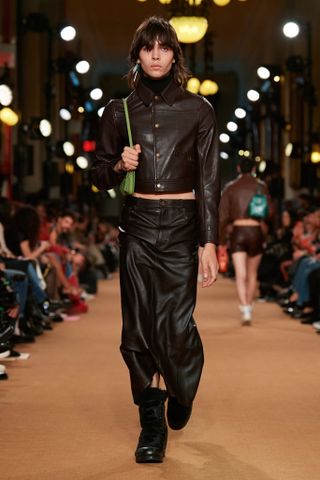 Boy on Coach runway in leather jacket skirt and boots