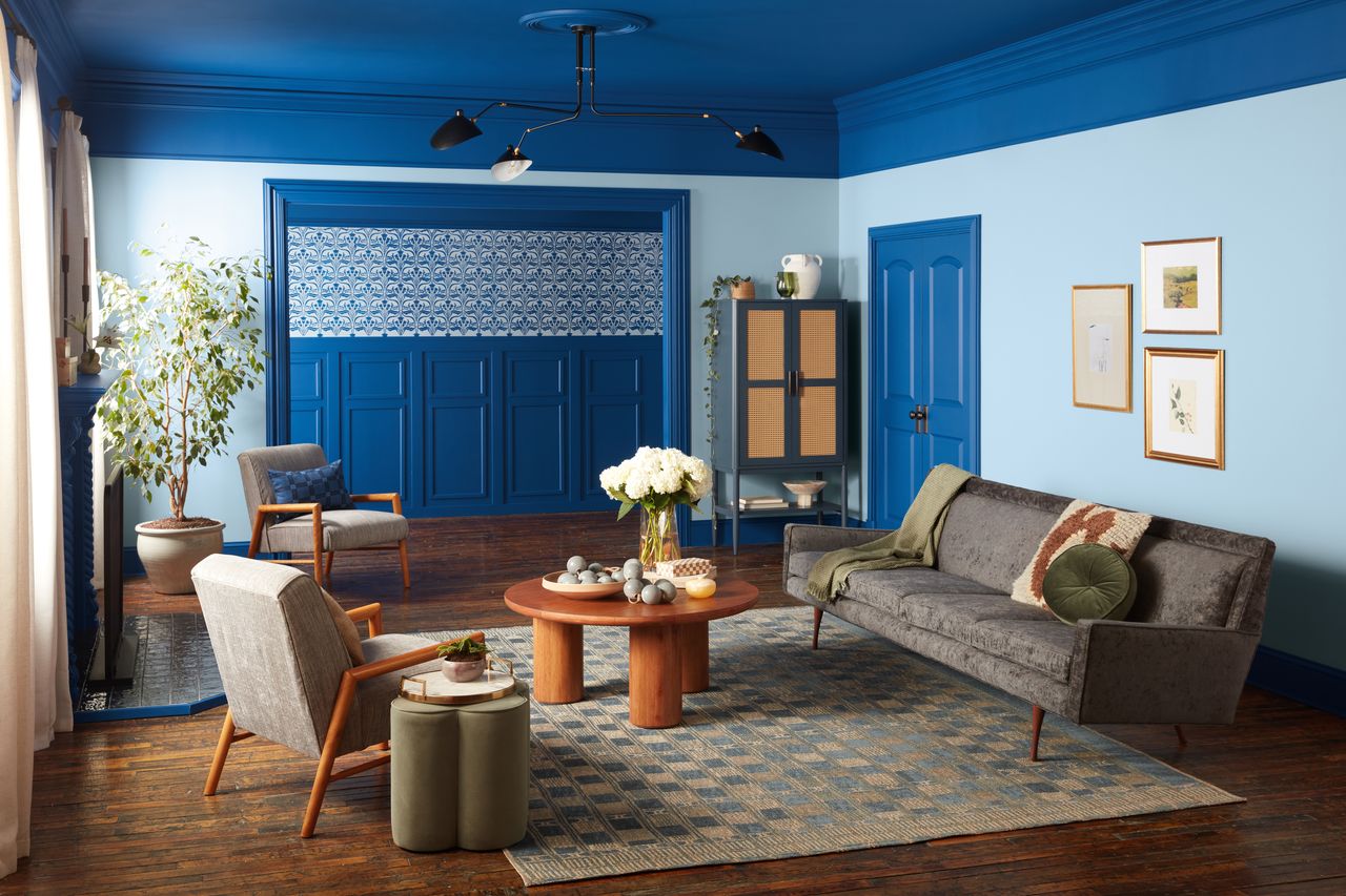 A living room with light blue walls and dark blue trim and ceiling 