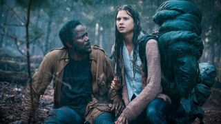 Bästa Netflix-serier: Sara och Boyd sitter bredvid varandre ute i en skog i regnet, i Netflix-serien From.