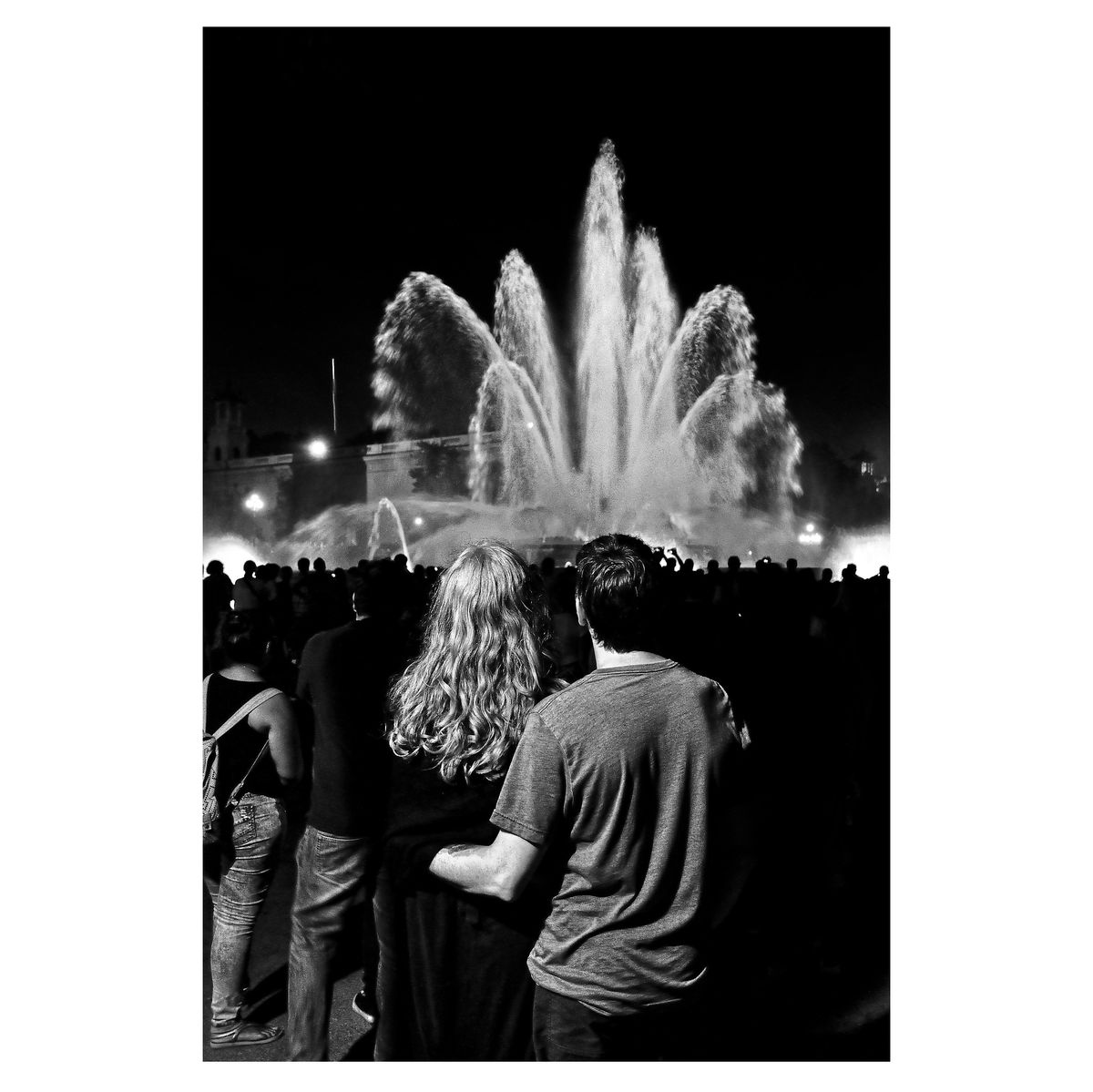 Black and white image of couple looking at fountain captured on the streets of Barcelona