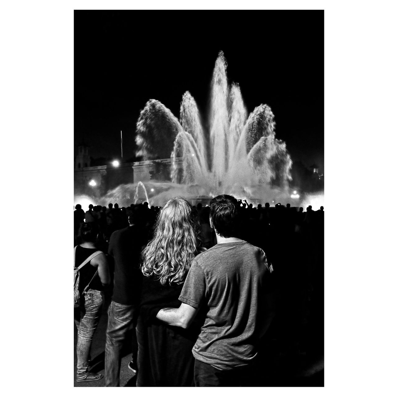 Black and white image of couple looking at fountain captured on the streets of Barcelona