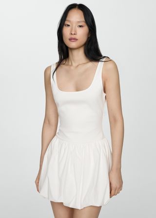 Model is wearing a white bubble hem tank dress