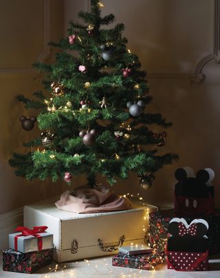 christmas tree with gift bags and mickey mouse themed baubles