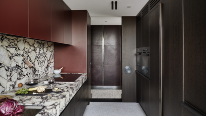 modern kitchen with calcatta viola counters and backsplash, and dark, burgundy cabinets