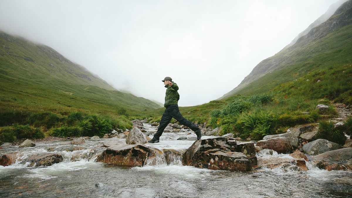 Low impact workouts: Man crossing river using stepping stones