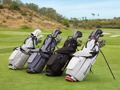 Four TaylorMade Golf golf bags filled with TaylorMade Golf clubs on a golf course.