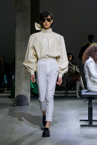 A model walks the Marni runway wearing the high neckline trend.