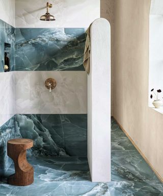 Wet room style bathroom with large shower area and tiled in marble-look tiles