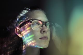Woman using computer with light reflecting on her face