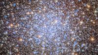 A starfield with bright stars in blue, white, yellow and orange. 