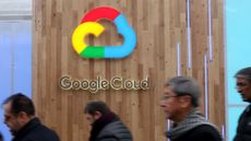 Google Cloud logo on a wooden background with pedestrians walking on a street in front of it