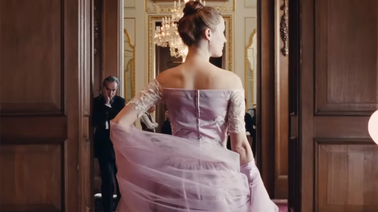 Expert tailoring in pink dress in Phantom Thread