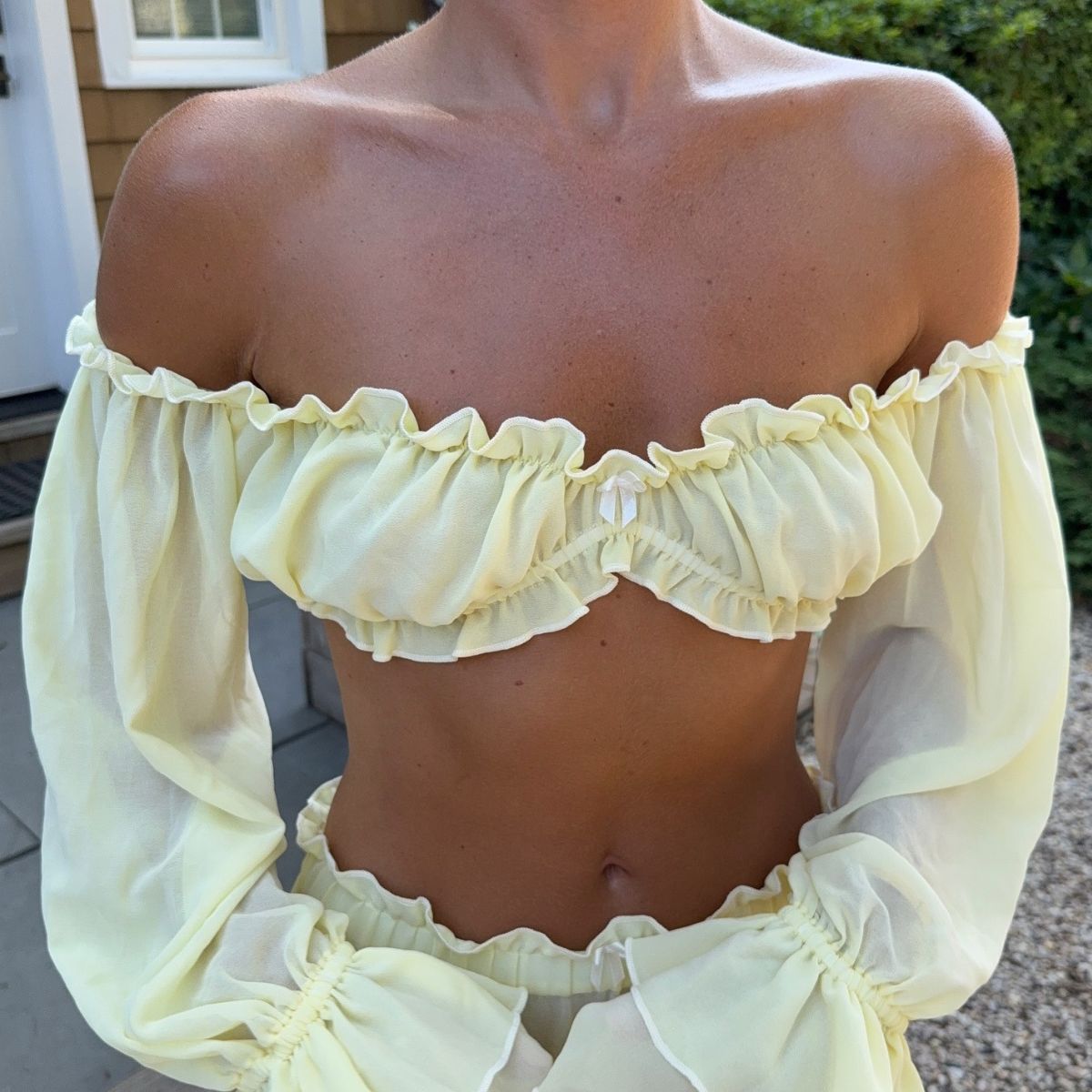 Creator @emmaleger wearing a yellow co-ord with a golden tan
