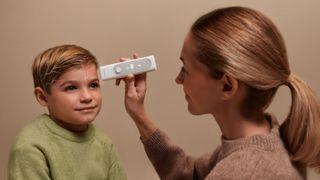 Photo showing a mother taking her son's temperature using the Withings BeamO multiscope
