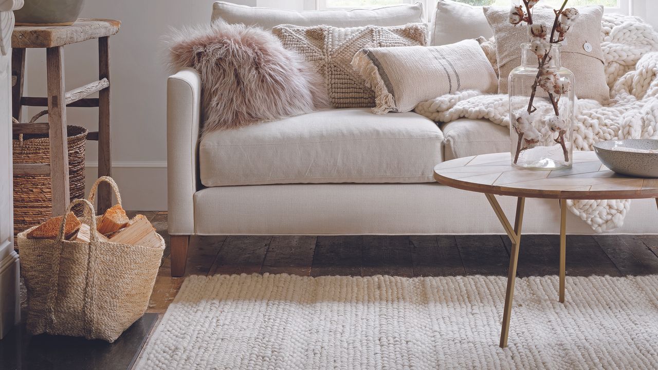 Living room with cream sofa and cream wool rug.