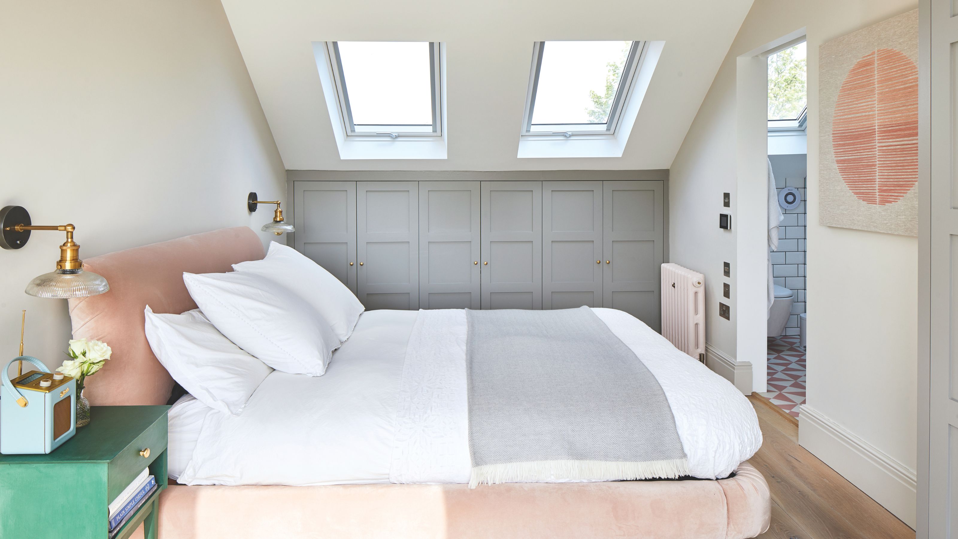 Loft conversion bedroom and en suite with rooflights overhead, and built-in wardrobes beneath