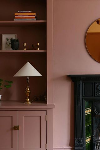 pink living room with shelving and fireplace