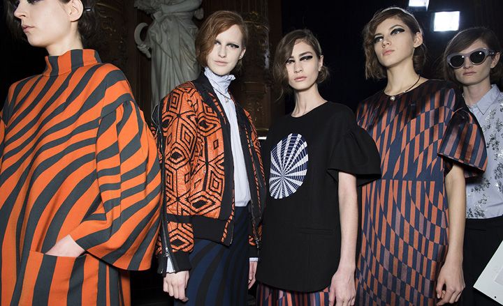 Female models stood in a line wearing black &amp; orange clothing