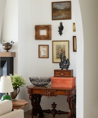 An antique dresser with a gallery wall hanging above