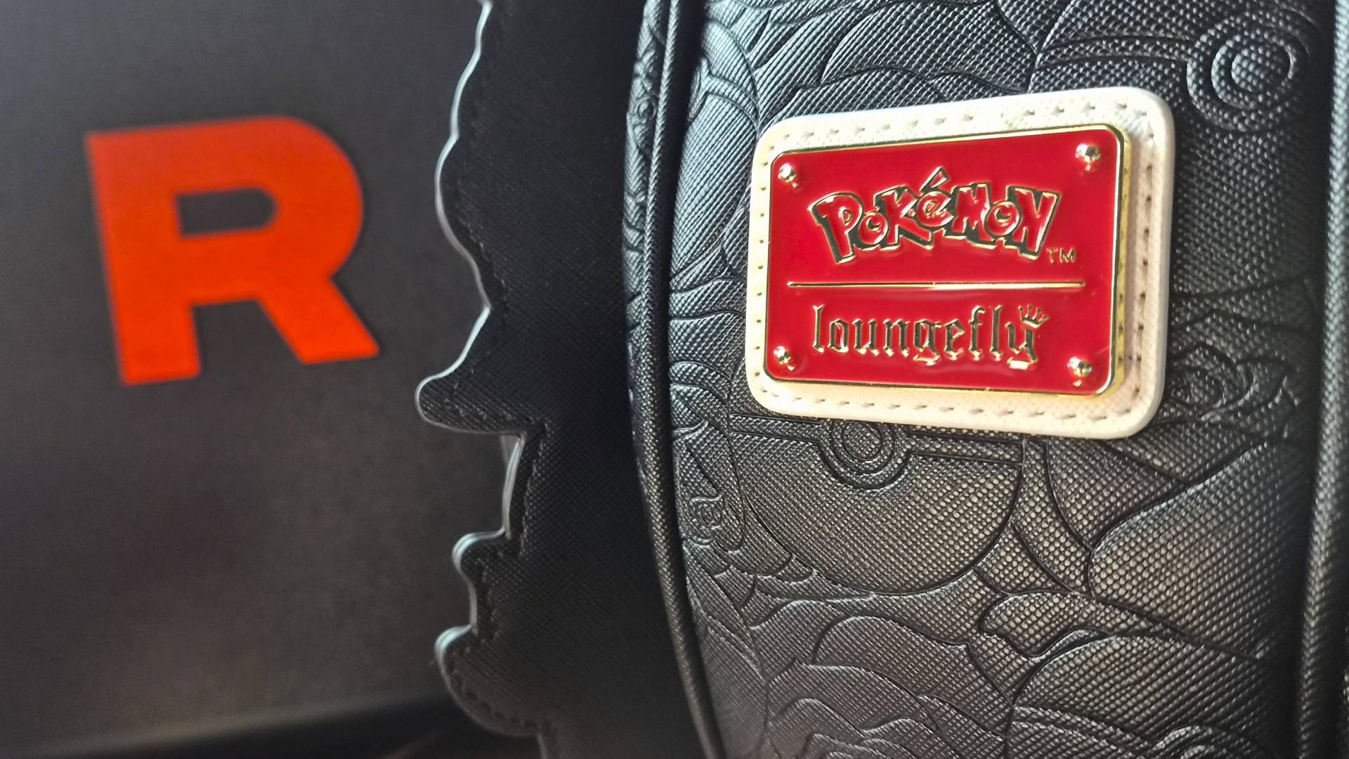 Close up of the Loungefly logo as found on the Team Rocket Cameo Mini Backpack.