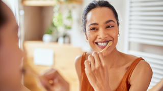 Woman brushing teeth in bathroom