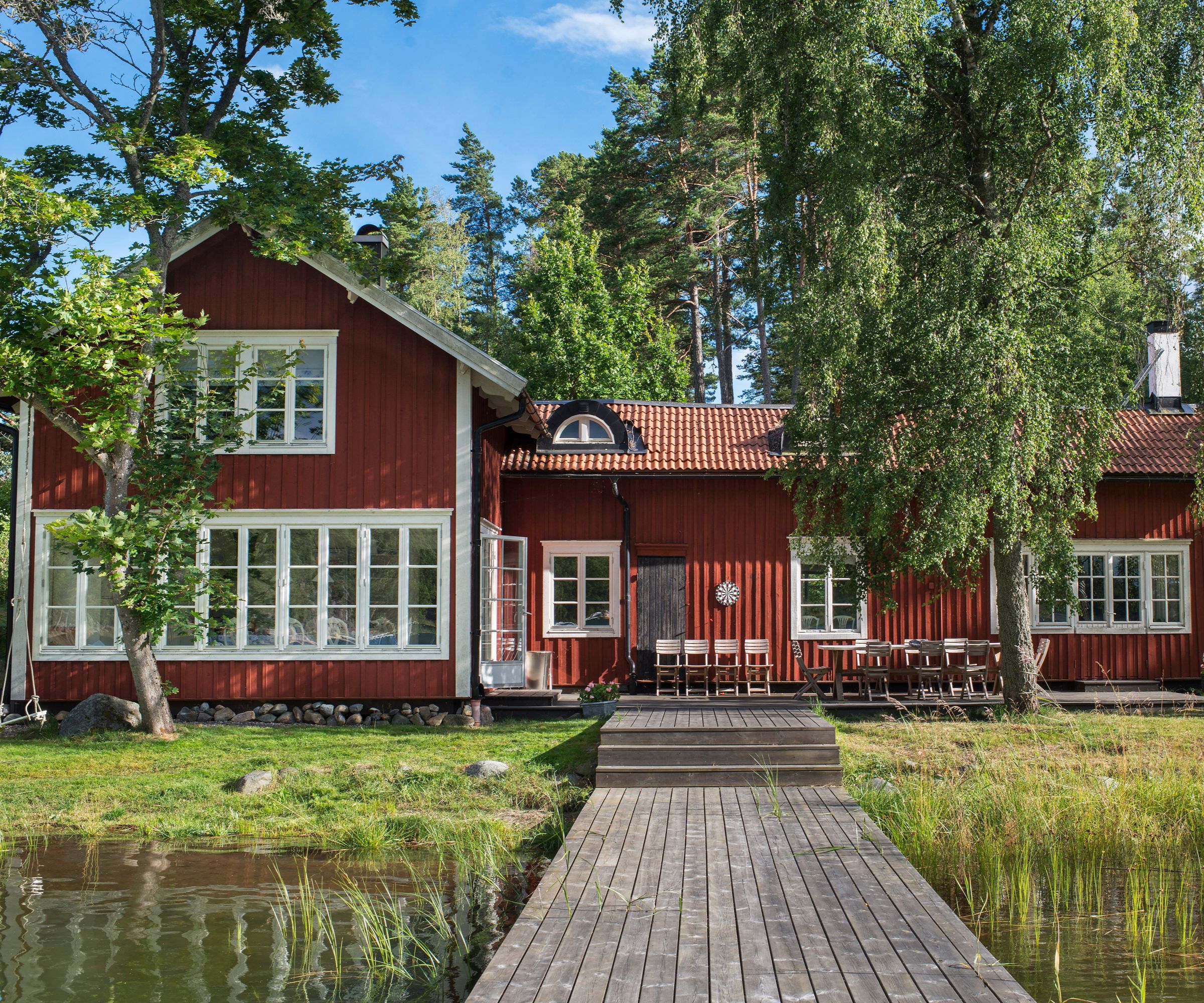 falu red painted traditional boathouse exterior with boardwalk