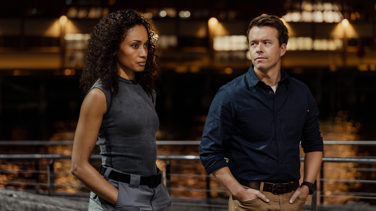 Olivia Swann's Mackey and Todd Lasance's JD standing next to each other outside in NCIS: Sydney