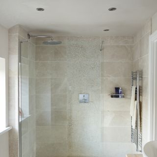 bathroom with cream colour tile wall spotlight shower cabin