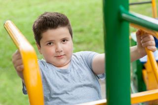 Overweight boy playing at the park.