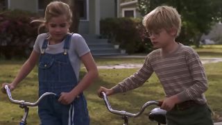 Anna Chlumsky and Macaulay Culkin walking with their bikes in My Girl.