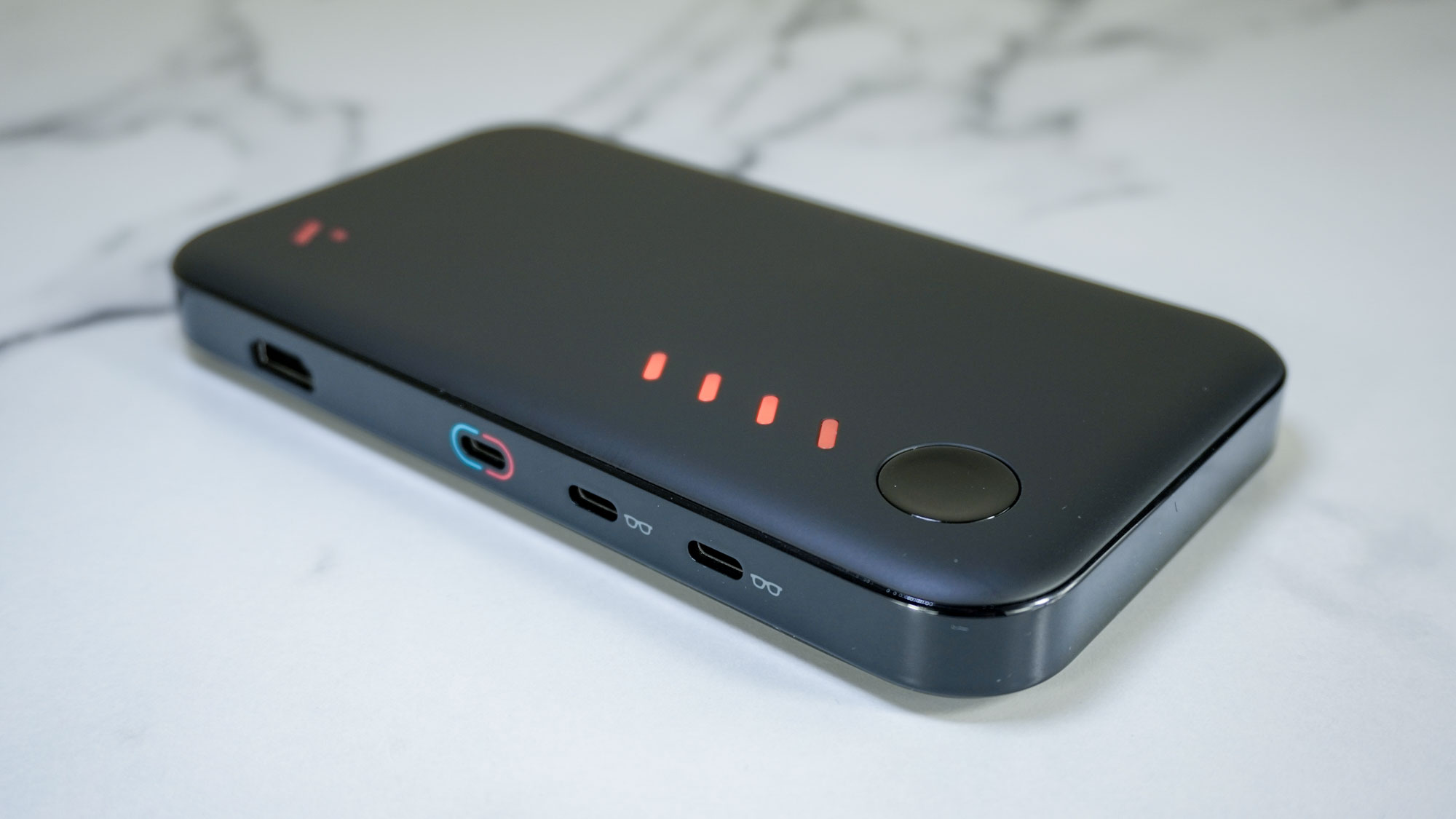 The Viture Pro Mobile Dock on a desk showing off its ports and the battery indicator lights on the top of the device