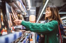 Young pretty woman doing grocery shopping in supermarket