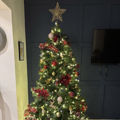 christmas tree with red and gold decorations and a star on the top