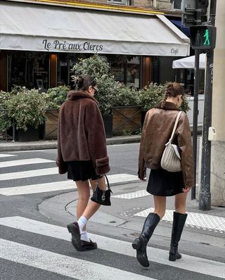 two French women wearing brown jackets and black miniskirts