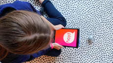 Image of child holding a tablet with the word play on it above a Sphero ball